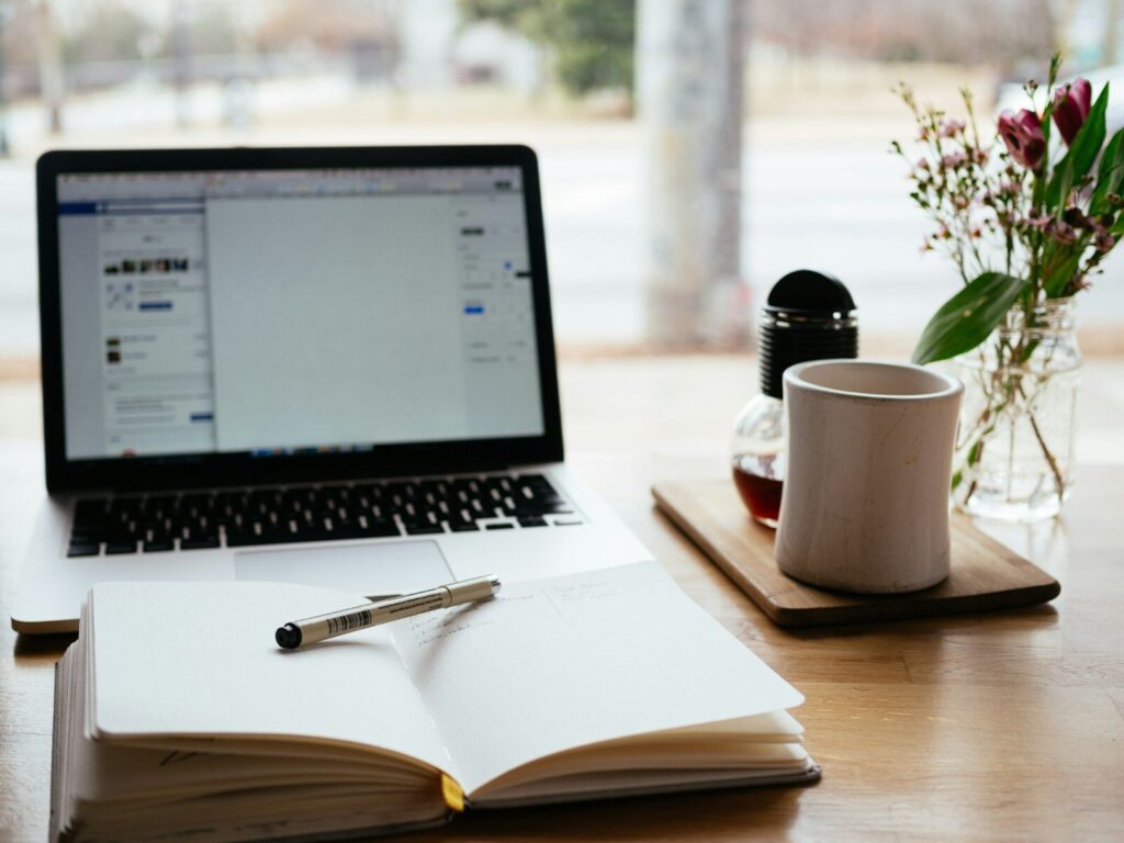 Content Marketing planen am Schreibtisch mit Laptop und Notizbuch